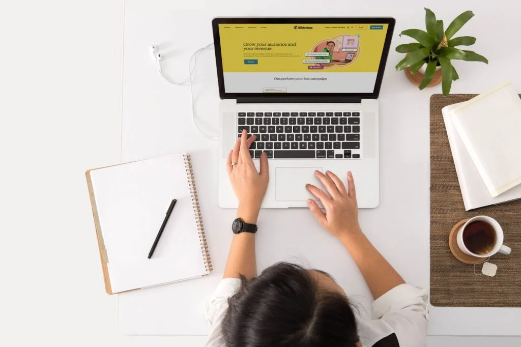 Mailchimp Pc desk with notebook and a woman type on it